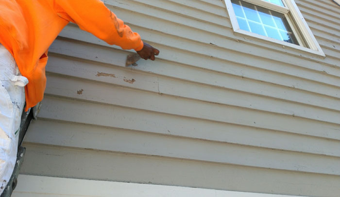 worker fixing siding